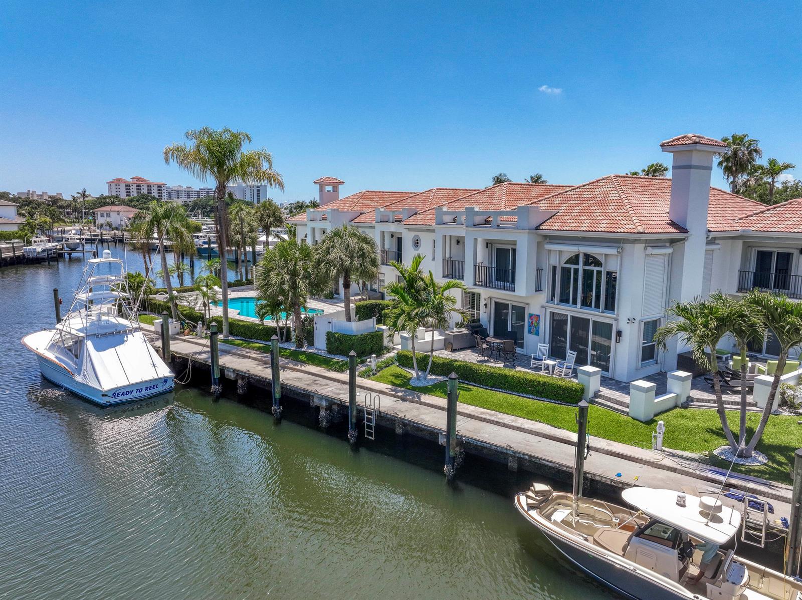An aerial view shows a waterfront house with a pool, dock, and two moored boats — 2245 Monet Road, North Palm Beach FL 33410, NORTH PALM BEACH, FL