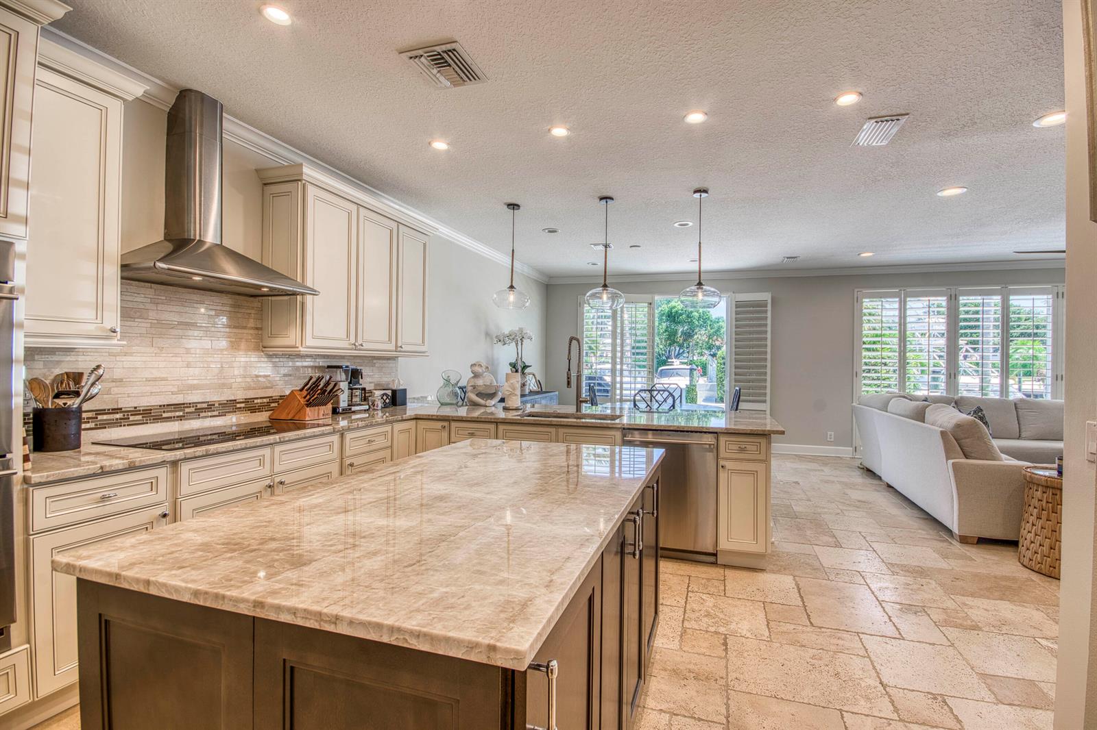 A kitchen with a large marble island, stainless steel appliances, and tile flooring — 2245 Monet Road, North Palm Beach FL 33410, NORTH PALM BEACH, FL