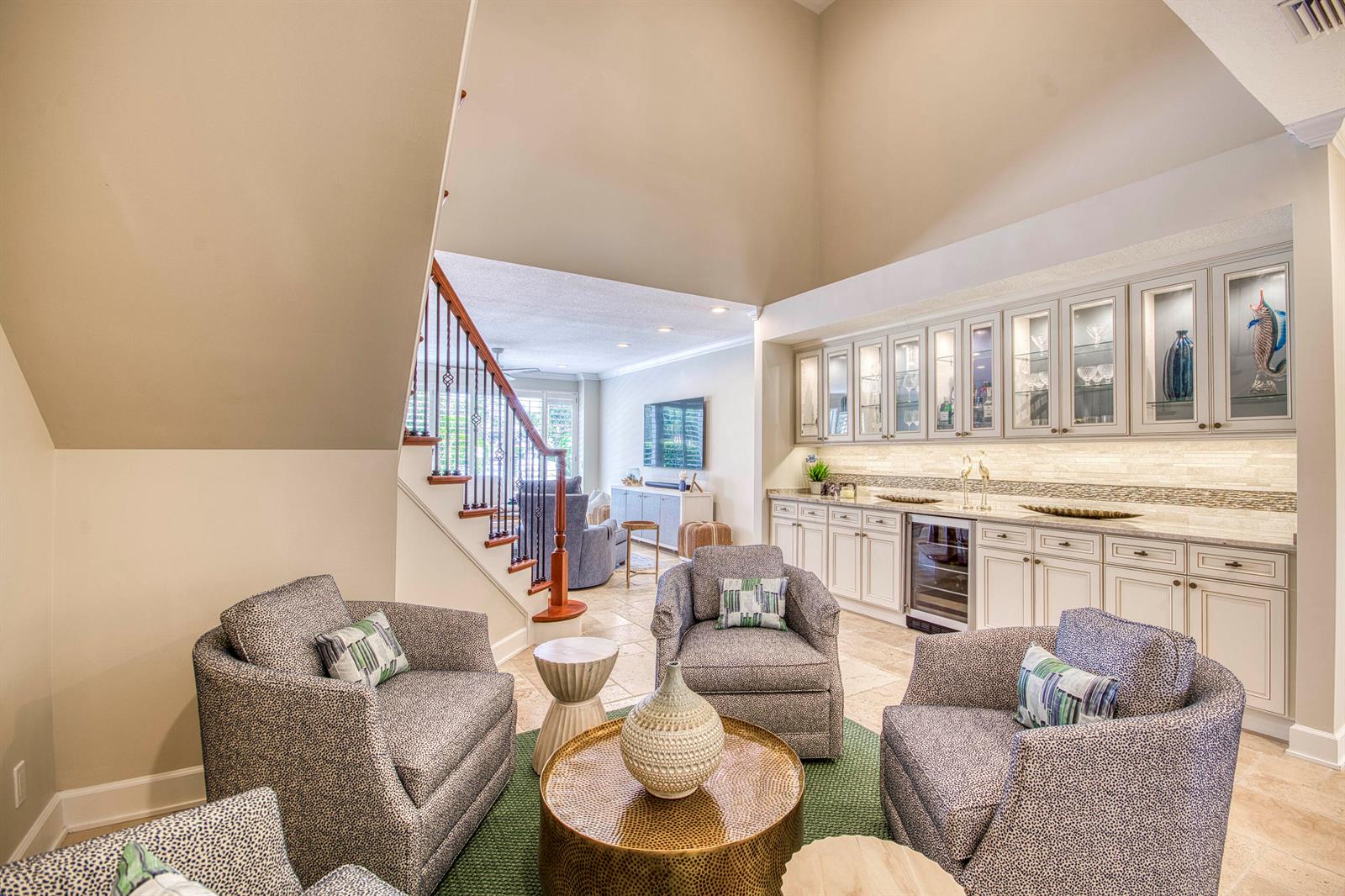 A living area with a wet bar, vaulted ceiling, and four patterned armchairs — 2245 Monet Road, North Palm Beach FL 33410, NORTH PALM BEACH, FL