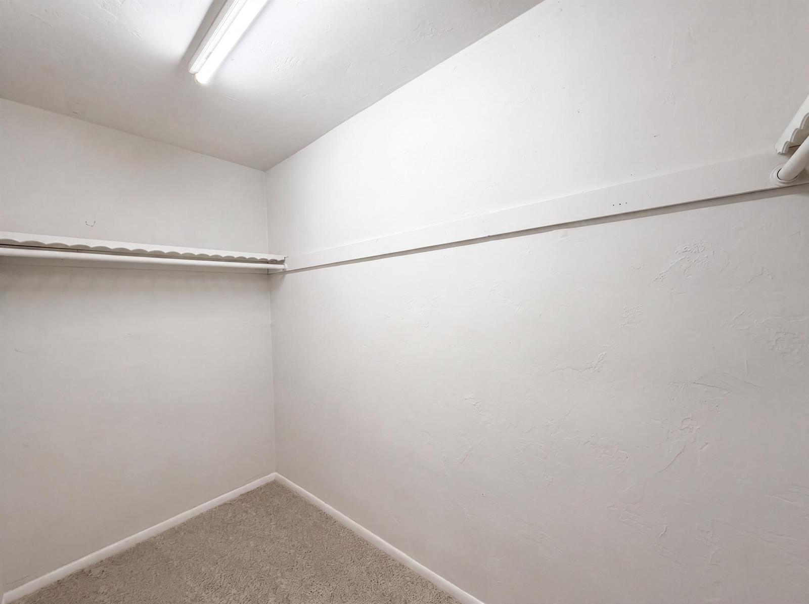 An empty walk-in closet features white walls, beige carpeting, and a white shelf with rod — 7141 Harbour Boulevard, Miramar FL 33023, MIRAMAR, FL