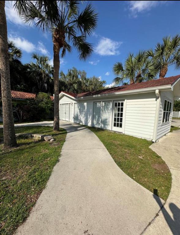 A white exterior building with a red roof sits beside a curved concrete walkway — 1895 SW LITTLE ROAD UNIT E, LAKE CITY, FL