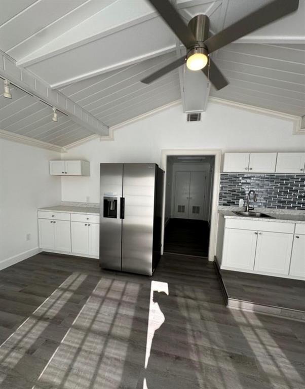 A kitchen features white cabinets, a stainless steel refrigerator, and a vaulted ceiling with fan — 1895 SW LITTLE ROAD UNIT E, LAKE CITY, FL