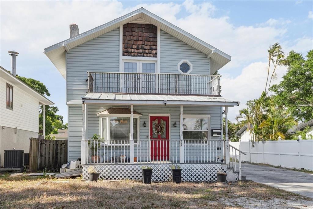 A two-story light blue house features a front porch, a balcony, and a red door — 757 32ND AVENUE N, ST PETERSBURG, FL