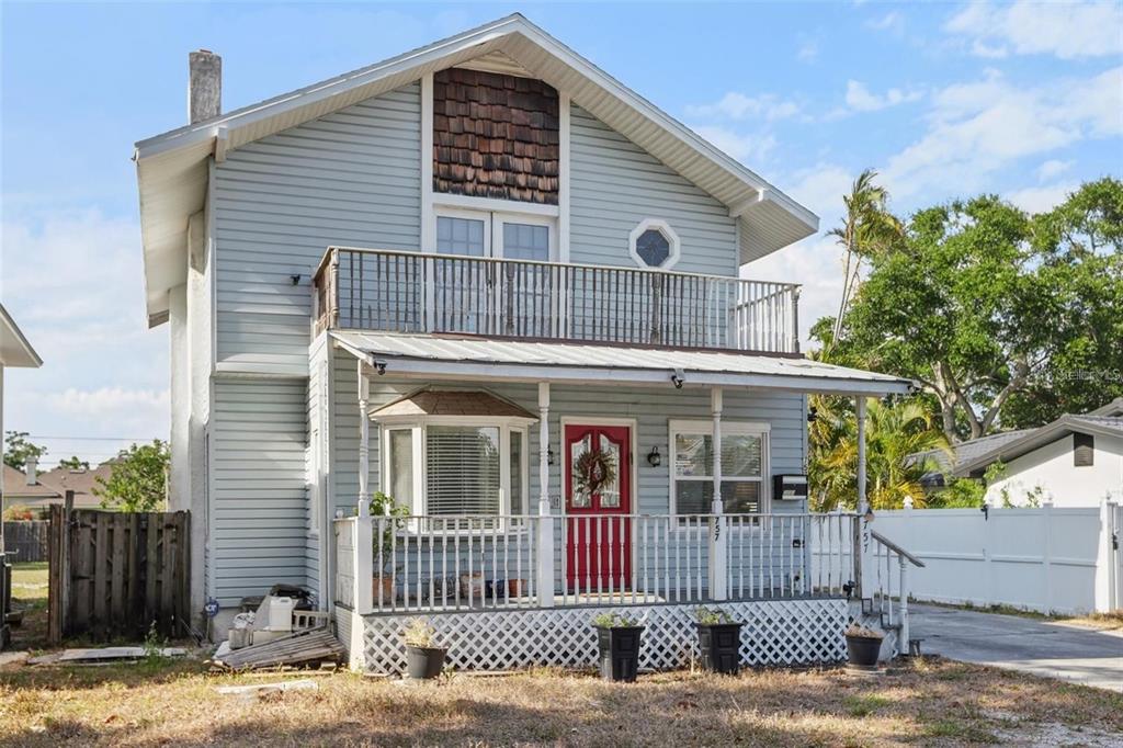 A two-story light blue house with a front porch, a balcony, and a red door — 757 32ND AVENUE N, ST PETERSBURG, FL