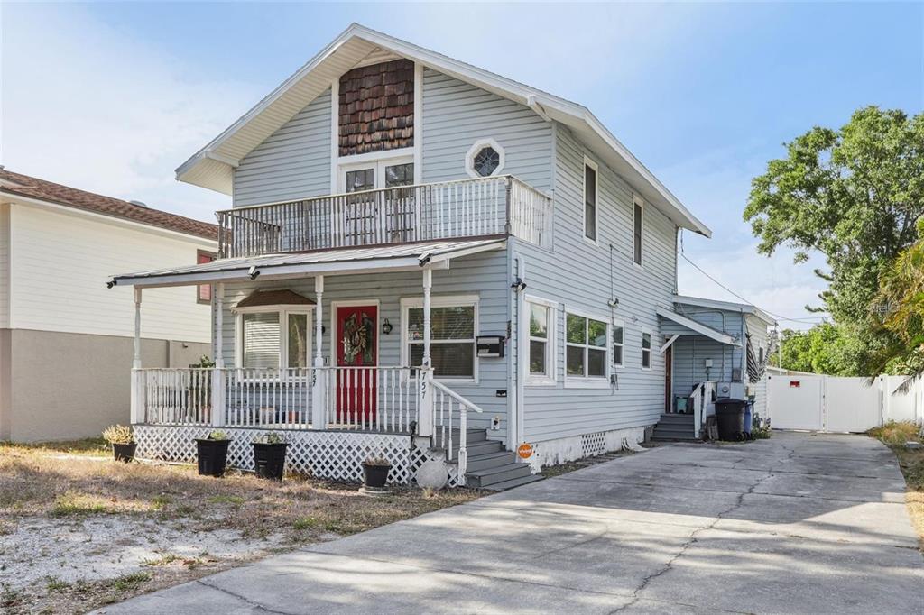 A two-story light blue house with a front porch, a balcony, and a concrete driveway — 757 32ND AVENUE N, ST PETERSBURG, FL
