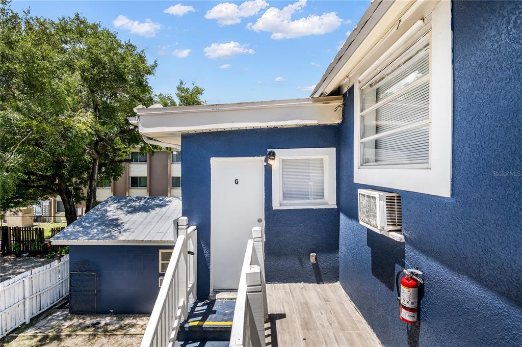 An exterior view of a blue building with a white door marked G and stairs — 418 E AMELIA AVENUE UNIT G, TAMPA, FL