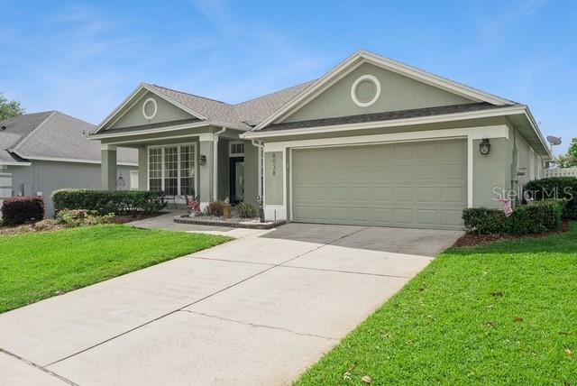 A single-story house with a green exterior, a two-car garage, and a concrete driveway — 8038 GLITTER COURT, ORLANDO, FL