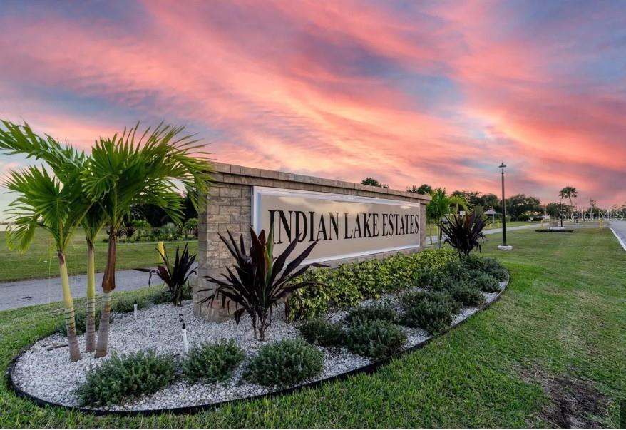 A stone monument sign for Indian Lake Estates stands in a landscaped bed at sunset — 411 INDIAN LAKE DRIVE, INDIAN LAKE ESTATES, FL