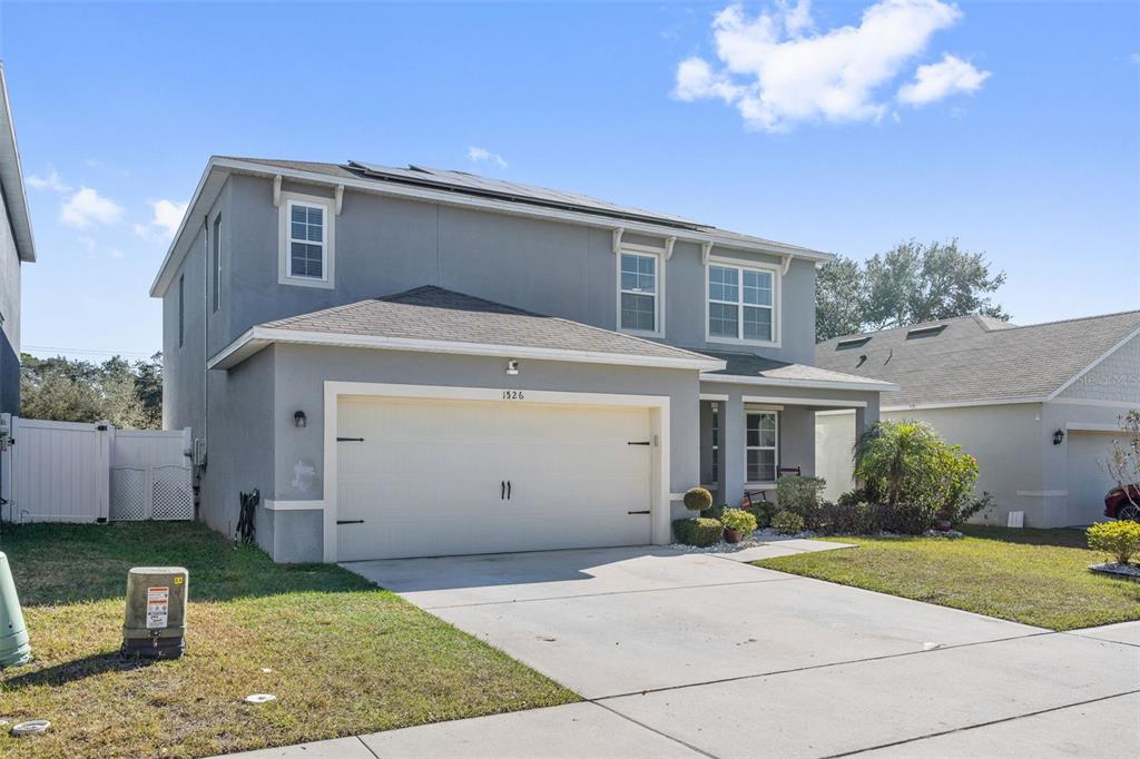 A two-story gray house with a two-car garage and a front lawn — 1526 WHITE HAWK WAY, GROVELAND, FL
