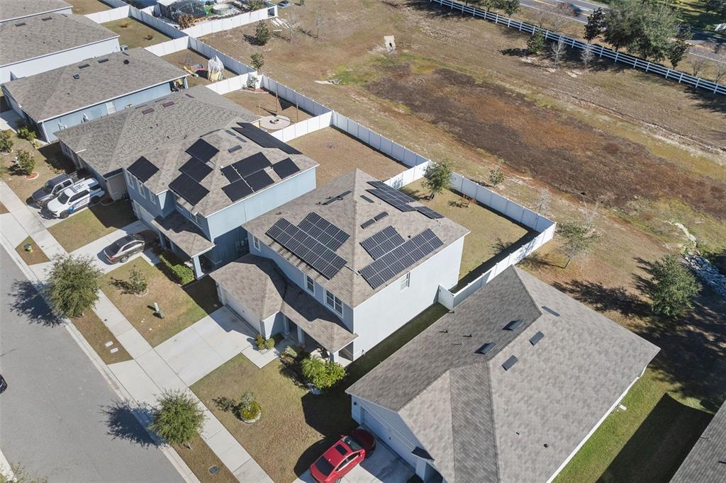 A two-story gray house with a two-car garage and solar panels on the roof — 1526 WHITE HAWK WAY, GROVELAND, FL