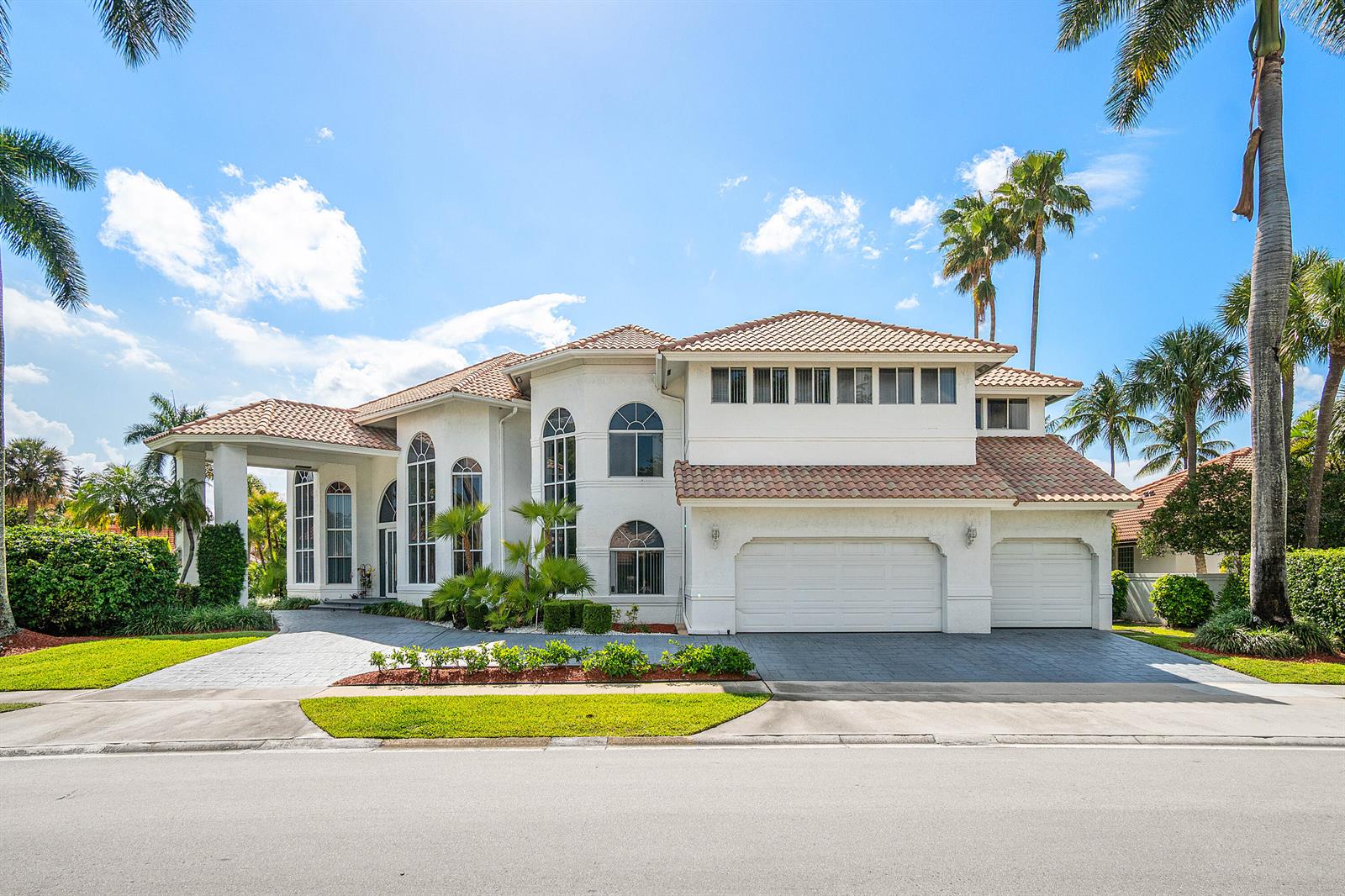 A two-story white stucco house with a tile roof, arched windows, and a three-car garage — 7173 Montrico Drive, Boca Raton FL 33433, BOCA RATON, FL