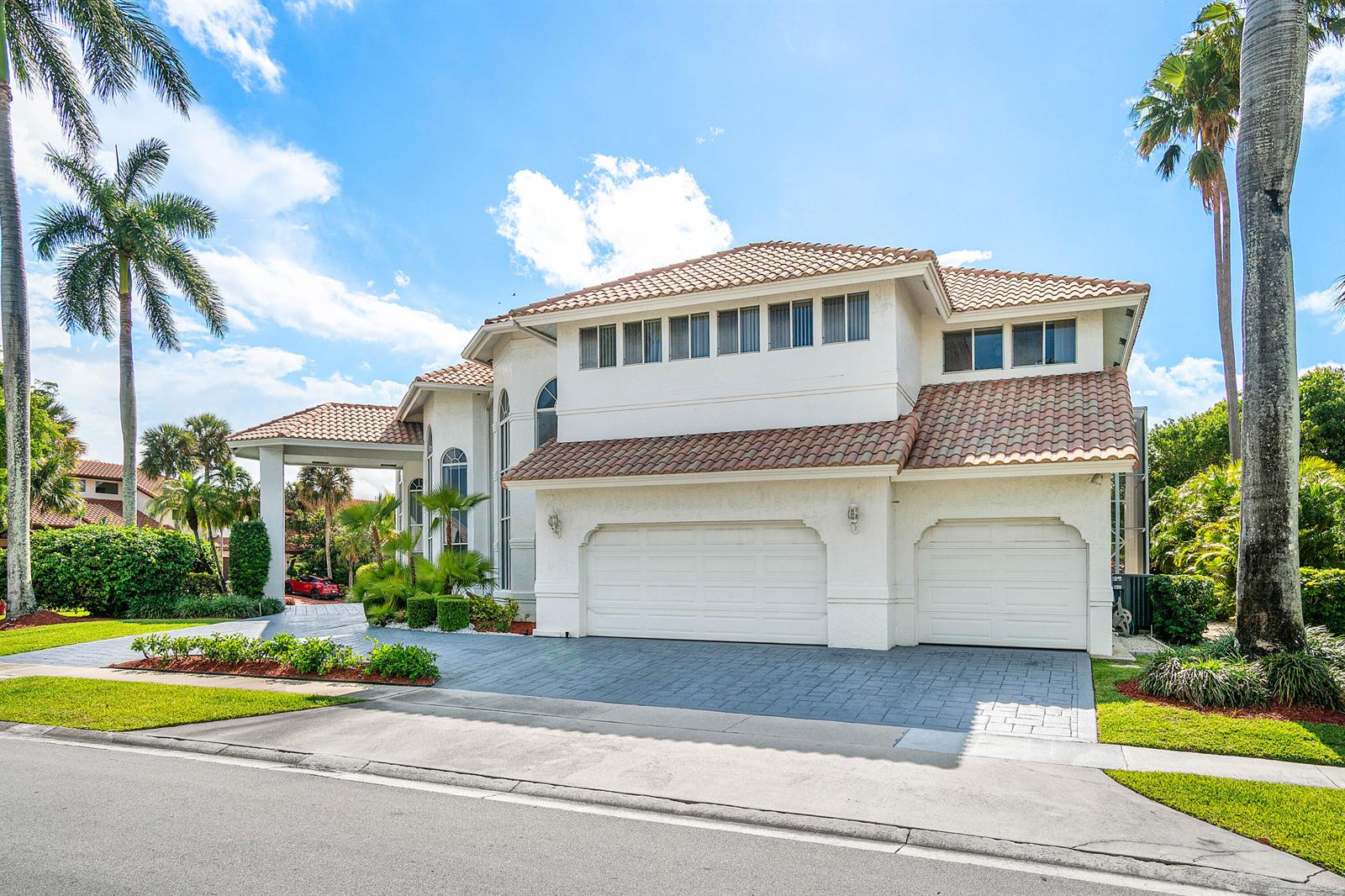 A two-story white house with a tiled roof, a three-car garage, and palm trees — 7173 Montrico Drive, Boca Raton FL 33433, BOCA RATON, FL