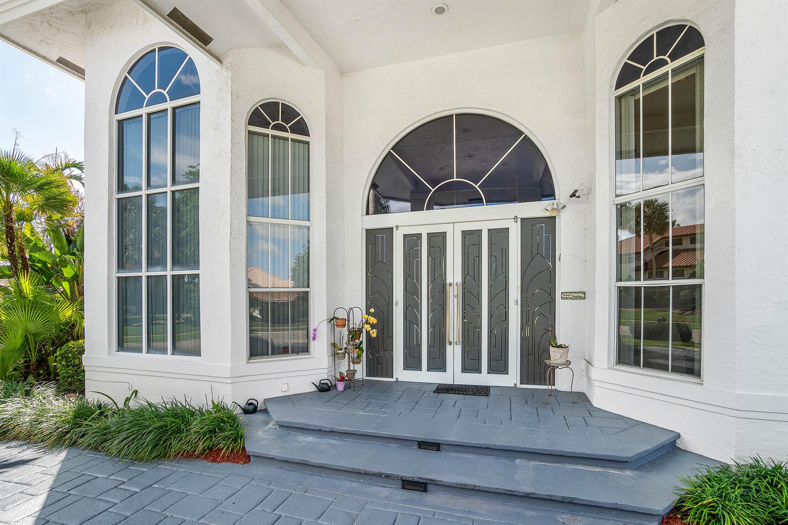The exterior of a white house features a double door entrance with arched windows — 7173 Montrico Drive, Boca Raton FL 33433, BOCA RATON, FL