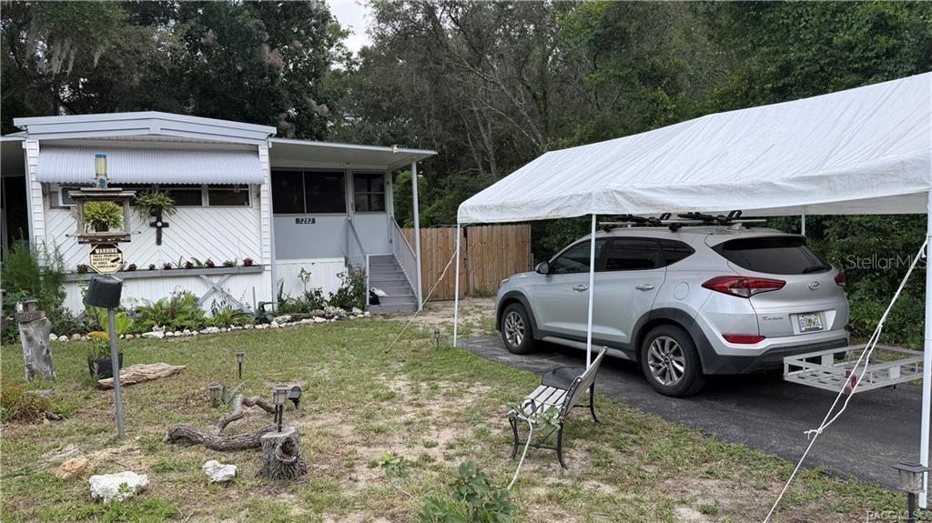 A white mobile home with a carport and a silver SUV parked in the driveway — 5282 W BLADE LANE, DUNNELLON, FL