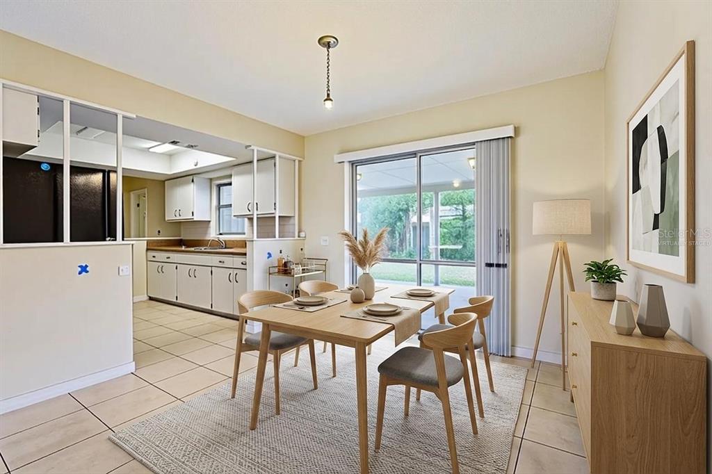 A dining room with a wooden table, chairs, and a view of a screened patio — 1806 DODGE CIRCLE, MELBOURNE, FL
