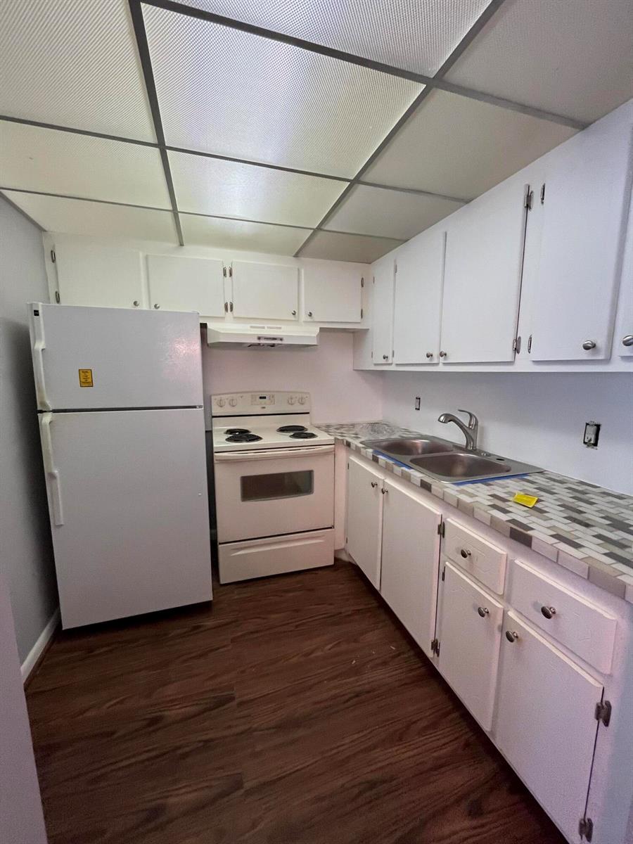 A kitchen features white cabinets, a white stove, a white refrigerator, and tiled countertops — 119 E Westbury E # 119, Deerfield Beach FL 33442, DEERFIELD BEACH, FL