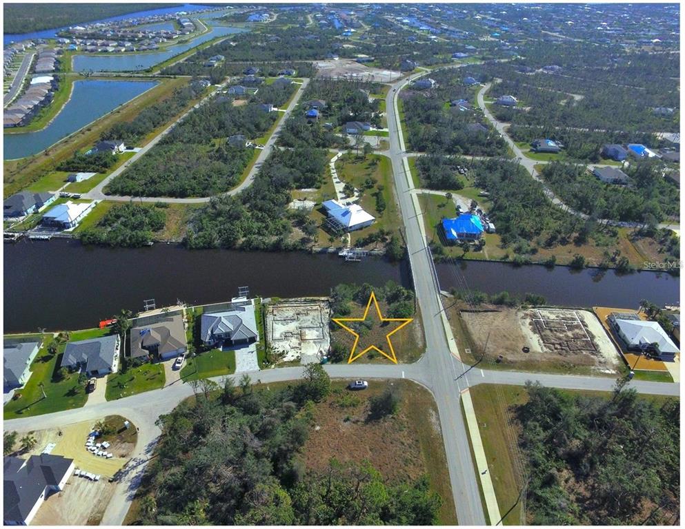 An aerial view shows a vacant waterfront lot marked with a yellow star — 14270 SAN DOMINGO BOULEVARD, PORT CHARLOTTE, FL