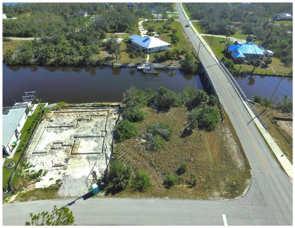 An aerial view shows a vacant waterfront lot with a building foundation under construction — 14270 SAN DOMINGO BOULEVARD, PORT CHARLOTTE, FL
