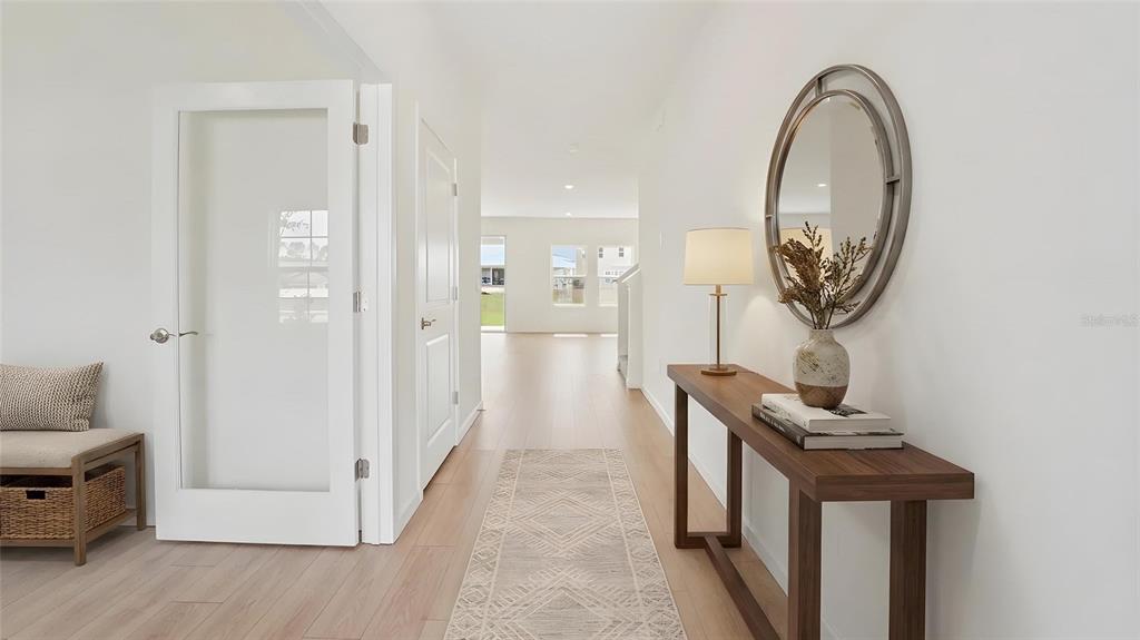 A bright entryway features a glass-paneled door, a console table with a mirror, and flooring — 17979 NW 172ND AVENUE, ALACHUA, FL