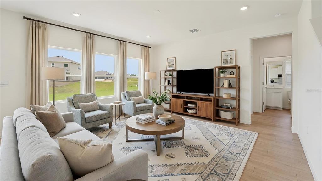 A living room features a grey sofa, two armchairs, a round coffee table, and a television — 17979 NW 172ND AVENUE, ALACHUA, FL