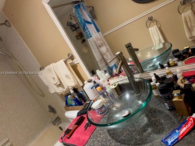 A bathroom features a glass vessel sink, a shower, and a patterned shower curtain — 4174 Inverrary Dr # 605, Lauderhill FL 33319, LAUDERHILL, FL
