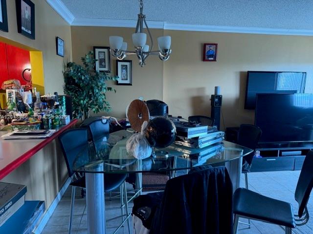 A dining area features a glass-topped table, black chairs, and a chandelier under a ceiling — 4174 Inverrary Dr # 605, Lauderhill FL 33319, LAUDERHILL, FL