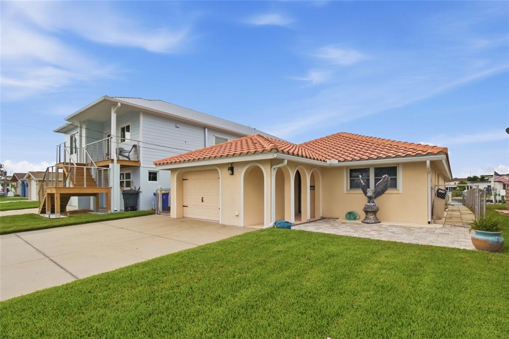 A single-story house with a tile roof, arched entryway, and attached garage sits on a lawn — 4549 TOPSAIL TRAIL, NEW PORT RICHEY, FL