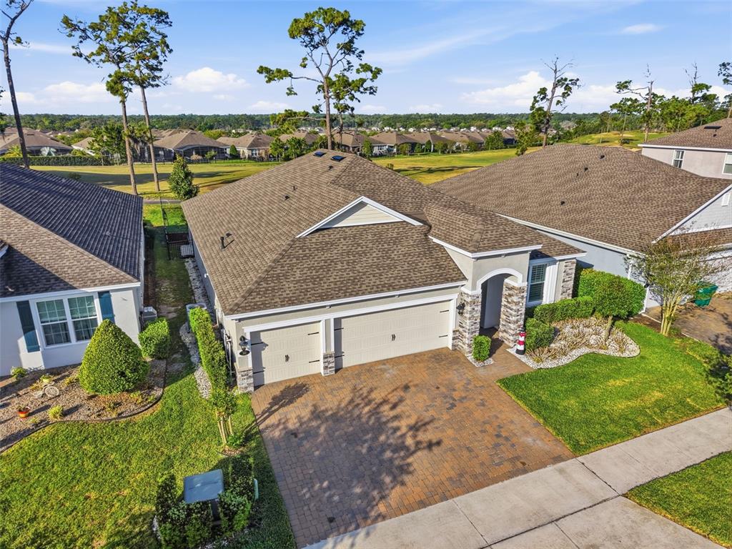 An aerial view of a suburban house with a three-car garage and paved driveway — 262 NORTHCOTE COURT, DELAND, FL