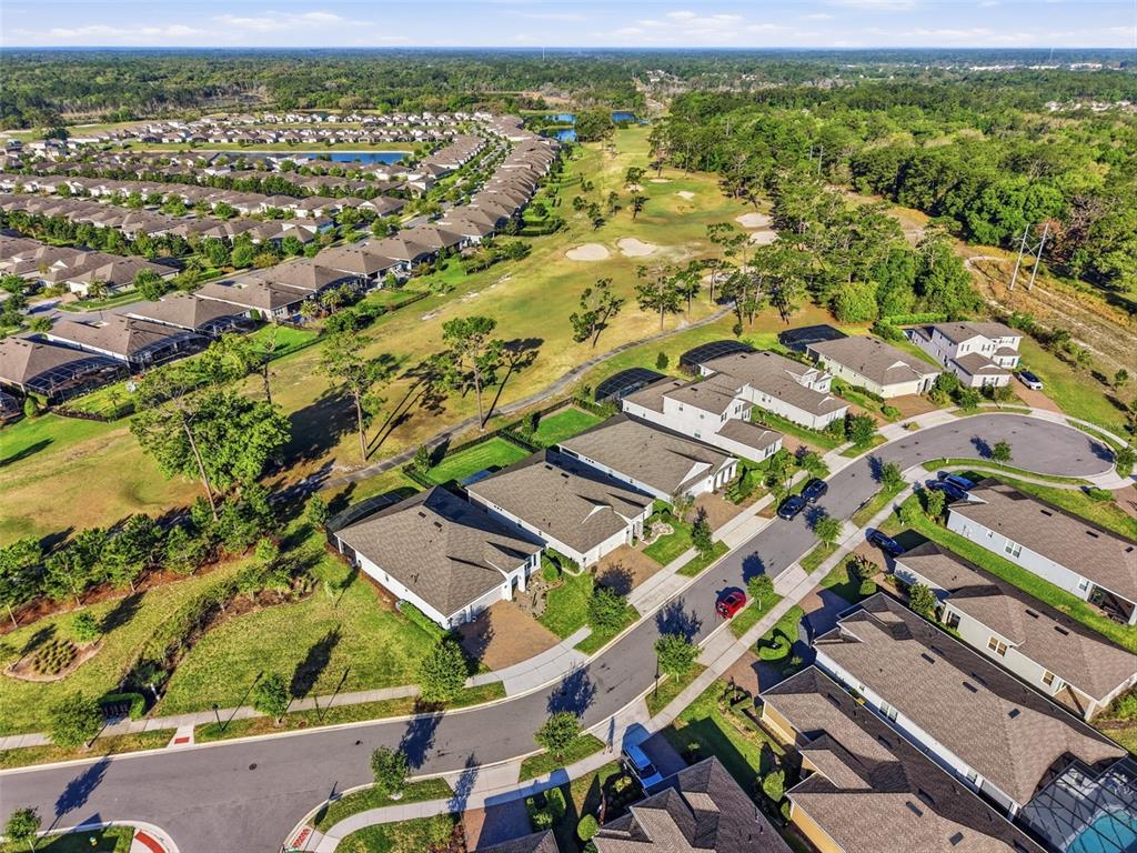 An aerial view shows a suburban neighborhood with houses bordering a golf course — 262 NORTHCOTE COURT, DELAND, FL