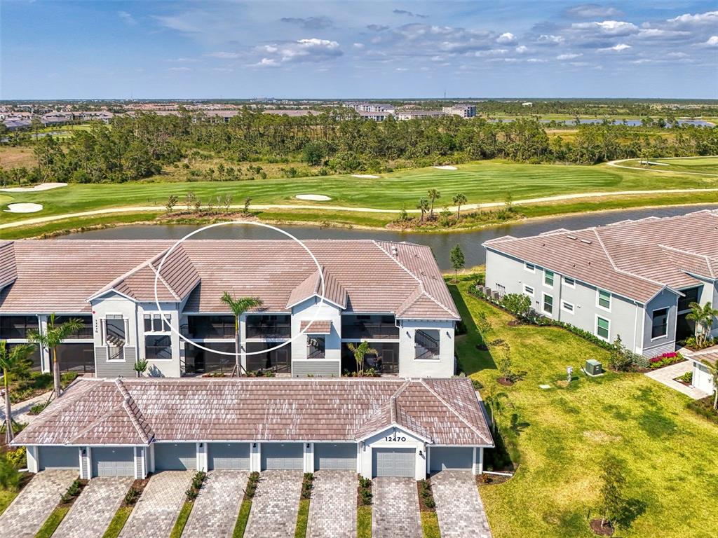 An aerial view shows the exterior of a multi-unit residential building with a tiled roof — 12470 WELLEN GOLF STREET UNIT 207, VENICE, FL