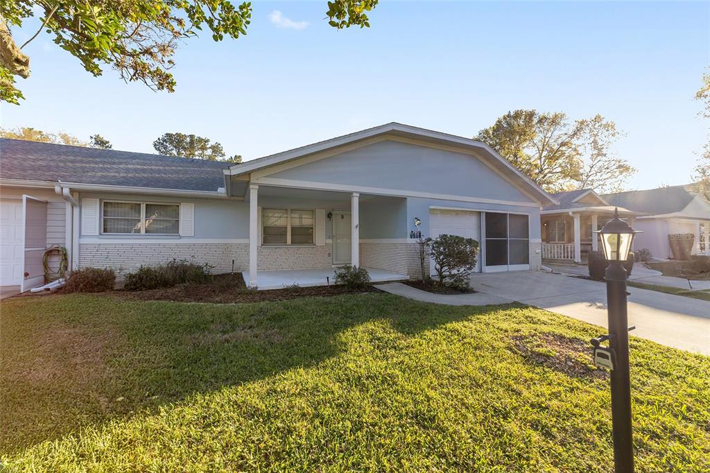 A covered front porch with a white brick base, a column, and a glass door — 8890 SW 96TH STREET UNIT B, OCALA, FL