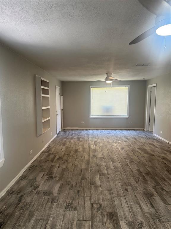 A living room with gray walls, wood-look tile flooring, a ceiling fan, and built-in shelving — 807 E OSBORNE AVENUE, TAMPA, FL