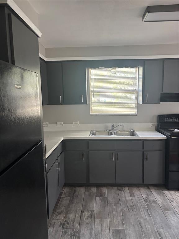 A kitchen features dark gray cabinets, white countertops, a double sink, and wood-look tile flooring — 807 E OSBORNE AVENUE, TAMPA, FL