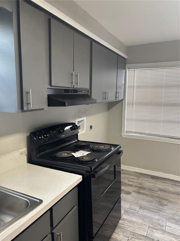A kitchen features gray cabinets, a black electric stove, and light-colored countertops — 807 E OSBORNE AVENUE, TAMPA, FL