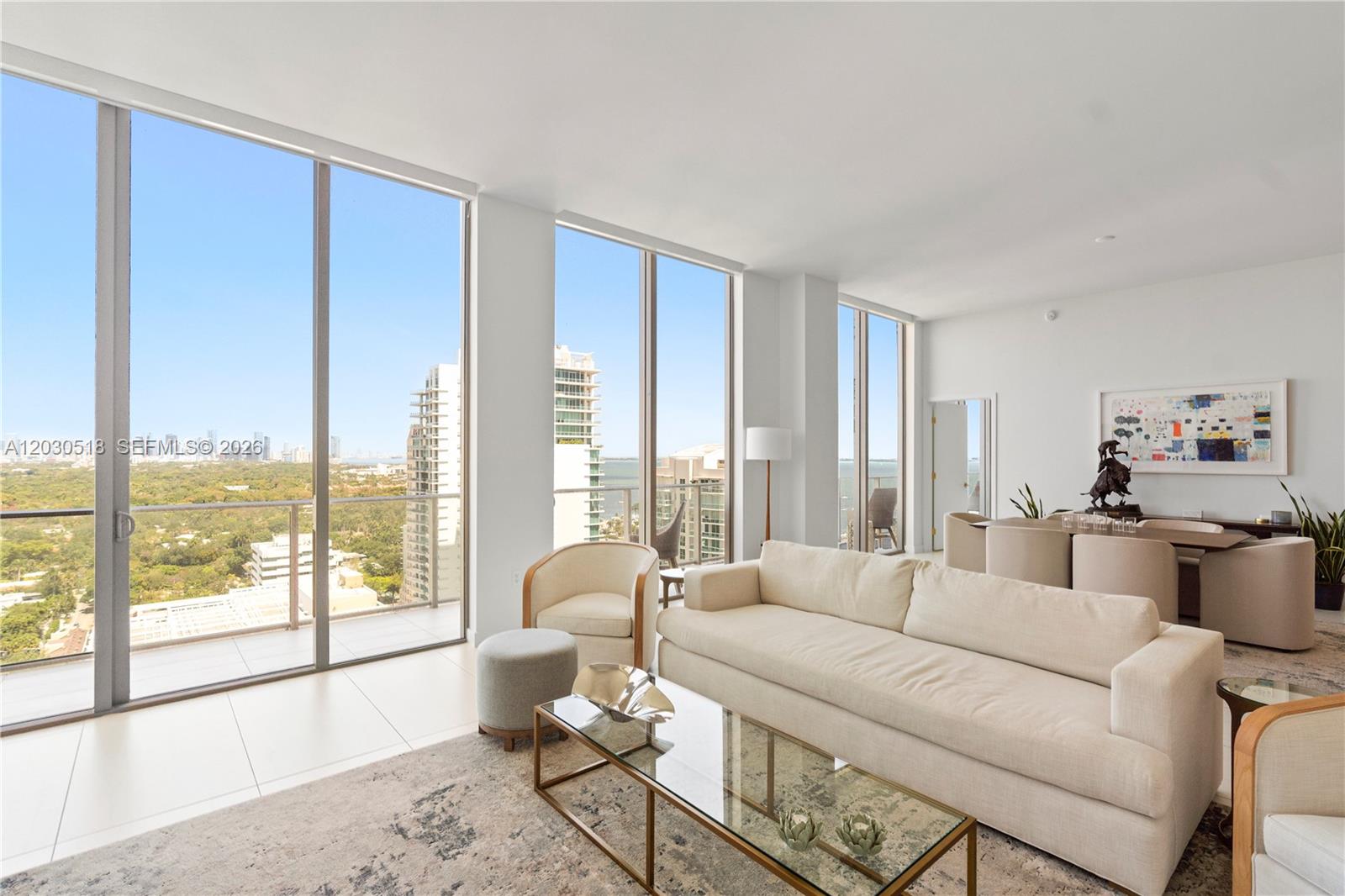 A bright living room features floor-to-ceiling windows, white tile floors, and a modern sofa — 2678 Tigertail Ave, Miami FL 33133, MIAMI, FL