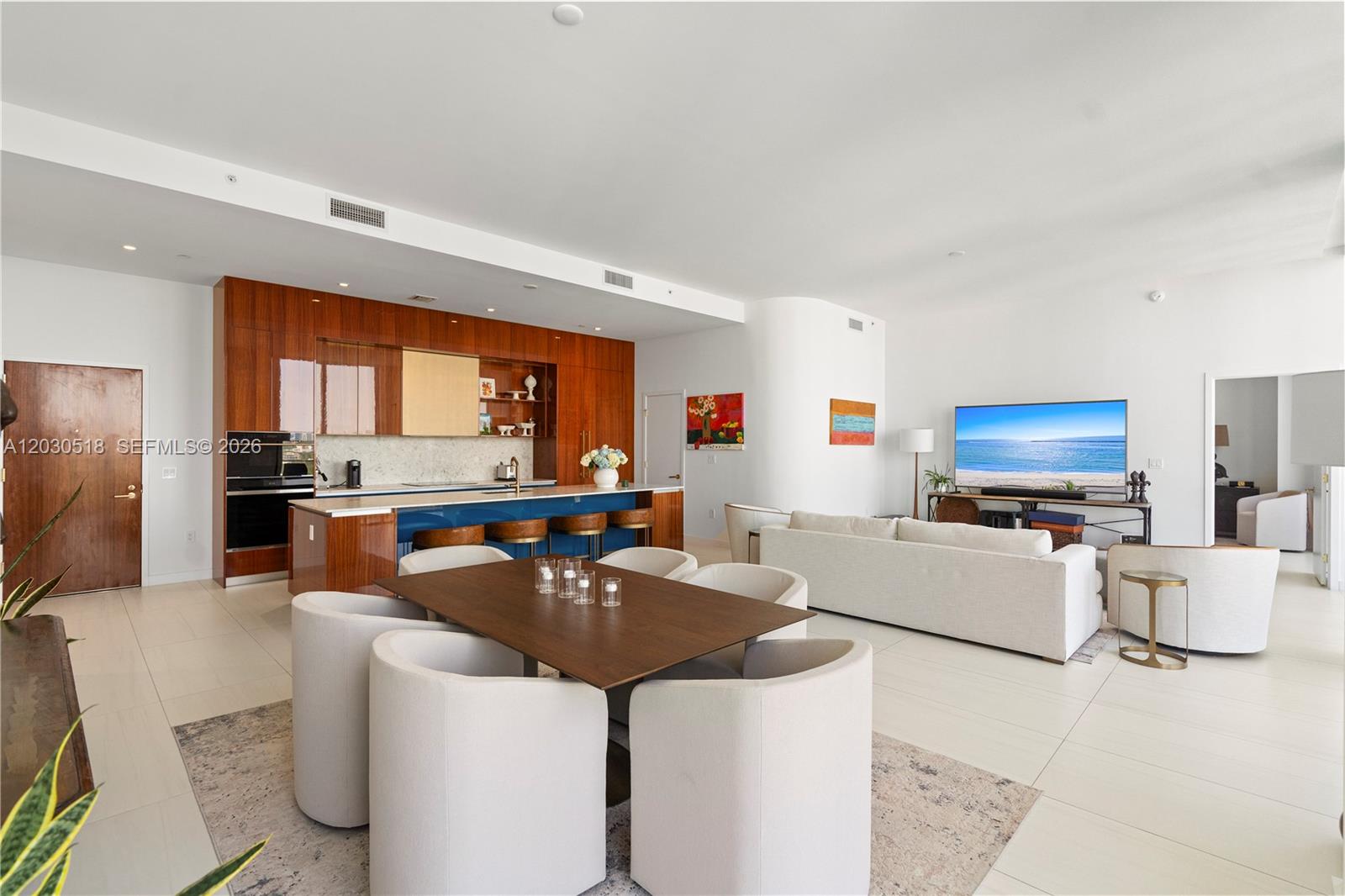 An open-concept living and dining area features a modern kitchen with wood cabinetry — 2678 Tigertail Ave, Miami FL 33133, MIAMI, FL