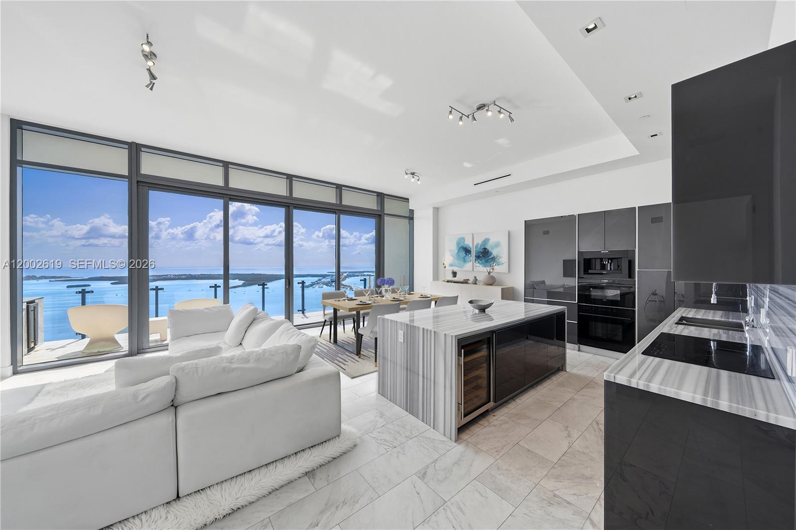 A modern open-plan living area features a kitchen with marble counters and floor-to-ceiling windows — 1451 Brickell Ave # 5101, Miami FL 33131, MIAMI, FL