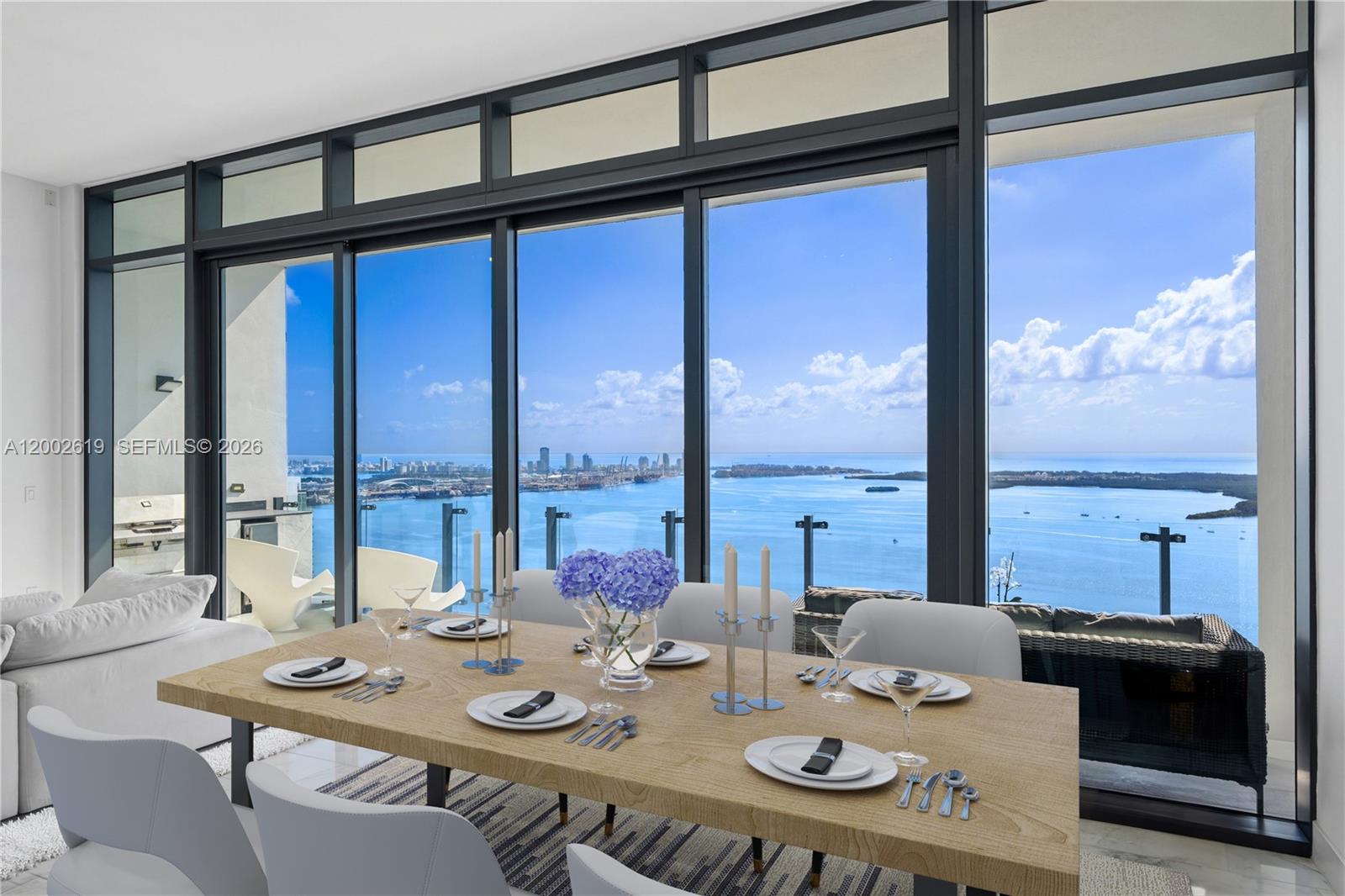 A dining room features a wooden table and floor-to-ceiling windows overlooking the ocean — 1451 Brickell Ave # 5101, Miami FL 33131, MIAMI, FL