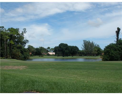 A view of a golf course fairway leading to a pond surrounded by trees — 21614 Juego Circle # 25h, Boca Raton FL 33433, BOCA RATON, FL