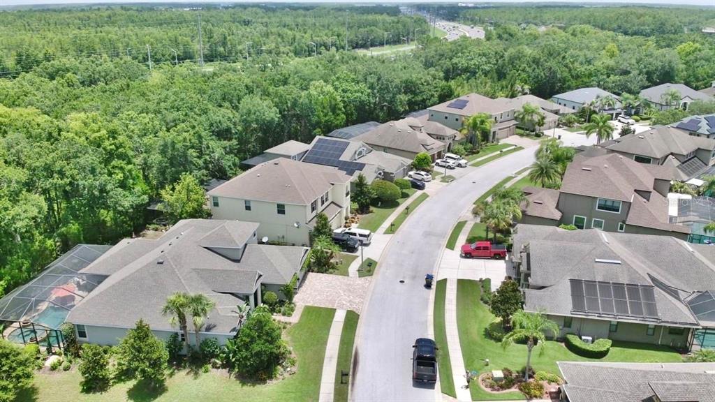 An aerial view shows a suburban street lined with houses, some featuring solar panels — 15321 AZRA DRIVE, ODESSA, FL
