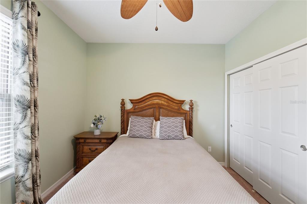 A bedroom features a wooden headboard, a nightstand, a bed, and a white closet — 212 GRANADA LANE, DAVENPORT, FL