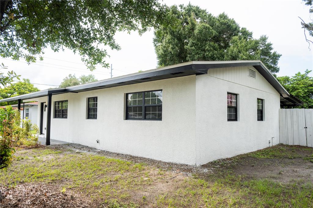 A white stucco house exterior with dark trim and a covered porch area — 4104 W WISCONSIN AVENUE, TAMPA, FL