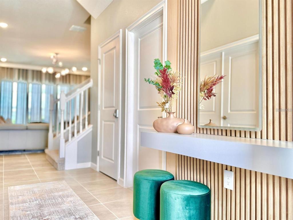 A hallway features a slatted wood accent wall, a floating shelf, and two green stools — 10012 VOYAGER WAY, ORLANDO, FL