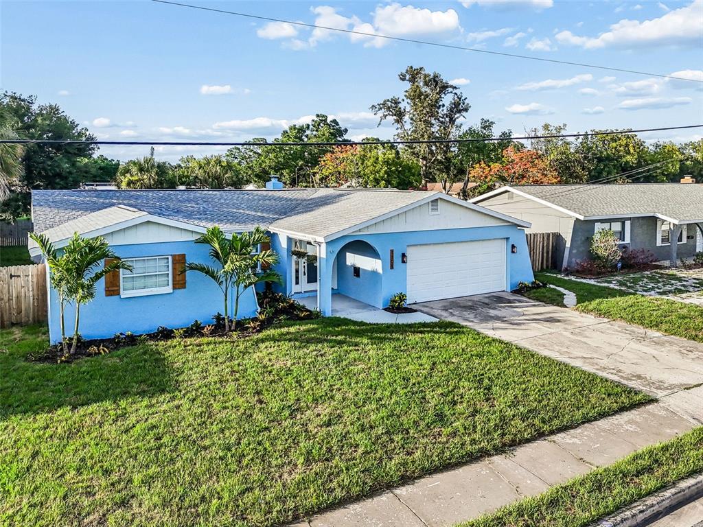 A single-story blue house with a white garage and a front lawn — 1101 54TH AVENUE S, ST PETERSBURG, FL