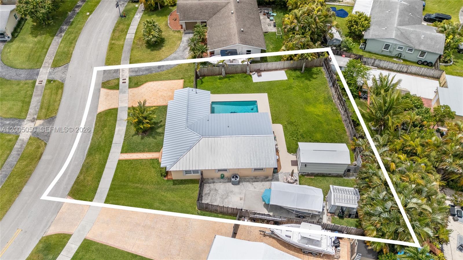 An aerial view shows a house with a metal roof, pool, and fenced backyard — 9411 SW 185th Ter, Cutler Bay FL 33157, CUTLER BAY, FL