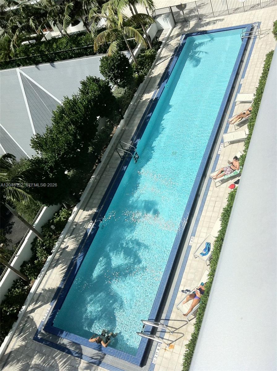 An elevated view of a long, rectangular outdoor swimming pool surrounded by lounge chairs — 1111 SW 1st Ave, Miami FL 33130, MIAMI, FL