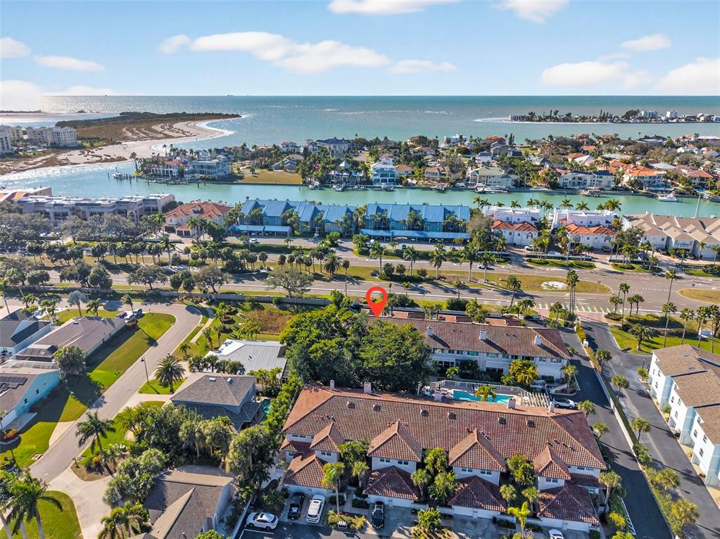 An aerial view shows a residential complex with tiled roofs near a coastal waterway — 903 PINELLAS BAYWAY S UNIT 308, TIERRA VERDE, FL