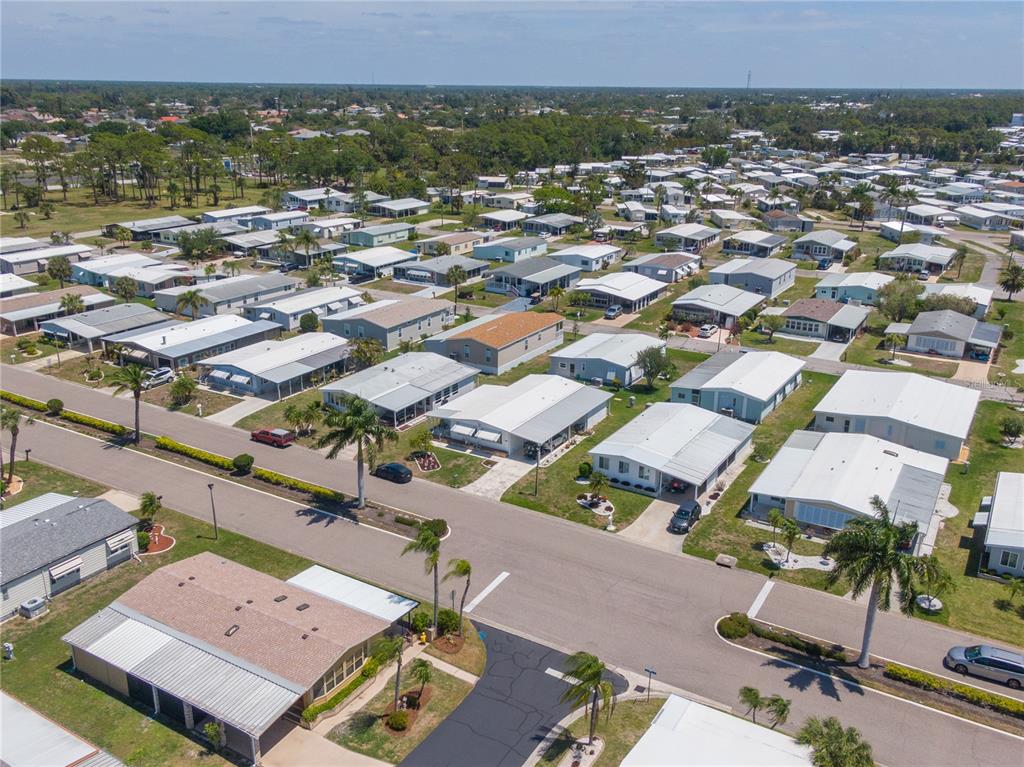 An aerial view shows a residential neighborhood of manufactured homes with palm trees and streets — 172 PALM HARBOR DRIVE, NORTH PORT, FL