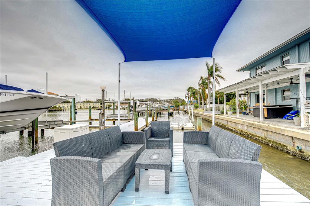 A view of a canal from a wooden dock with boat lifts and string lights — 300 VENETIAN DRIVE UNIT 2, CLEARWATER, FL