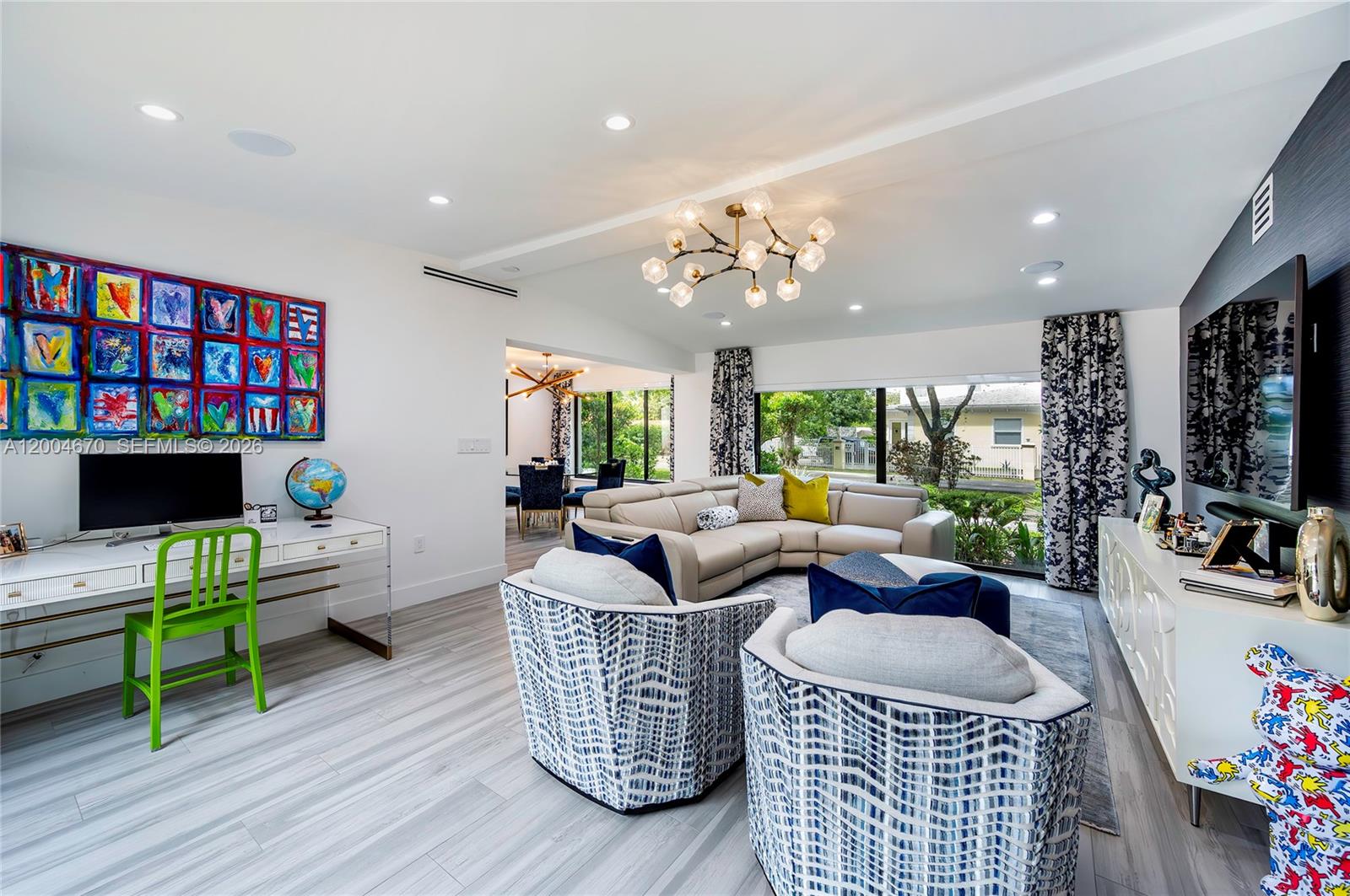 A modern living room features a sectional sofa, two patterned armchairs, and a desk area — 831 Cortez St, Coral Gables FL 33134, CORAL GABLES, FL